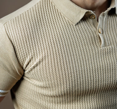 Textured knitted polo beige T-shirt with black trousers.