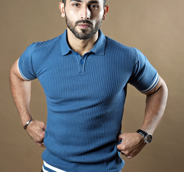 Textured knitted polo blue T-shirt with black trousers.