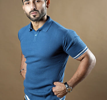 Textured knitted polo blue T-shirt with black trousers.