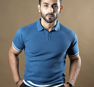 Textured knitted polo blue T-shirt with black trousers.