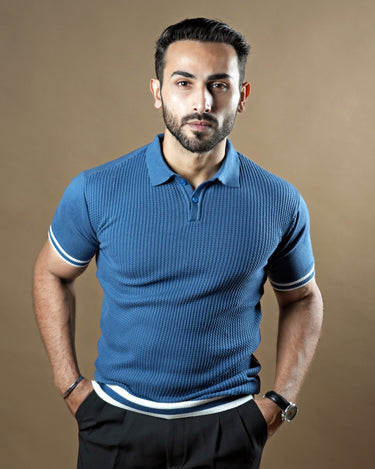 Textured knitted polo blue T-shirt with black trousers.