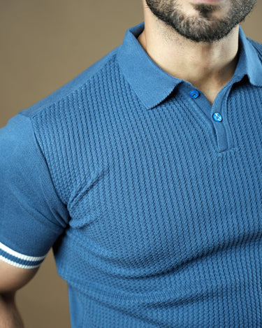 Textured knitted polo blue T-shirt with black trousers.