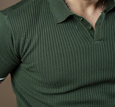 Textured knitted polo dark green T-shirt with black trousers.